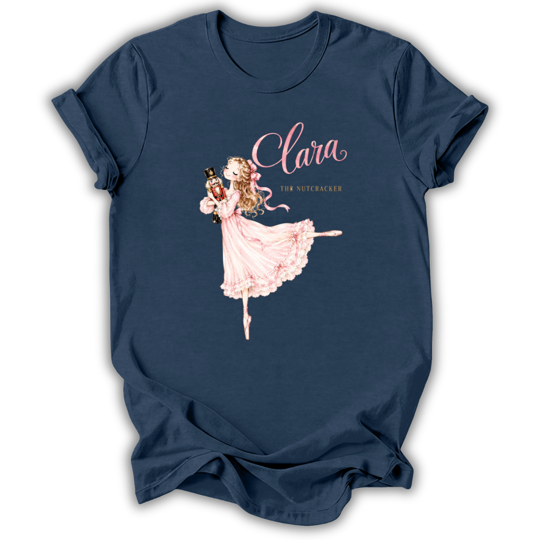 A navy blue short-sleeve t-shirt with a graphic print of a ballerina in a pink dress and the text 'Clara The Nutcracker'.