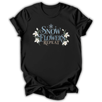 Black short-sleeve t-shirt with a graphic on the chest that reads 'SNOW FLOWERS REPEAT' in blue and gold lettering, decorated with white snowflakes and flowers, shown on a white background.