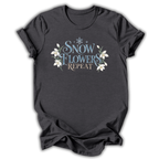 Dark gray short-sleeve t-shirt with a graphic on the chest that reads 'SNOW FLOWERS REPEAT' in blue and gold lettering, decorated with white snowflakes and flowers, shown on a white background.