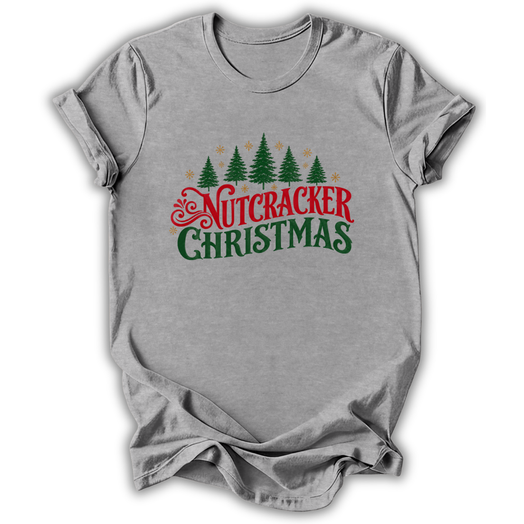 A heather gray short-sleeve t-shirt with a 'Nutcracker Christmas' graphic on the chest, featuring green pine trees and red and green text, displayed on a white background.