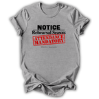 A heather gray short-sleeve t-shirt with a graphic print that reads 'NOTICE Rehearsal Season: ATTENDANCE MANDATORY' in black and red text, shown on a white background with a soft drop shadow.