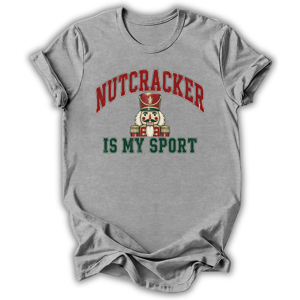 A heather gray short-sleeve t-shirt with a graphic print of a nutcracker and the text 'NUTCRACKER IS MY SPORT' in red and green.