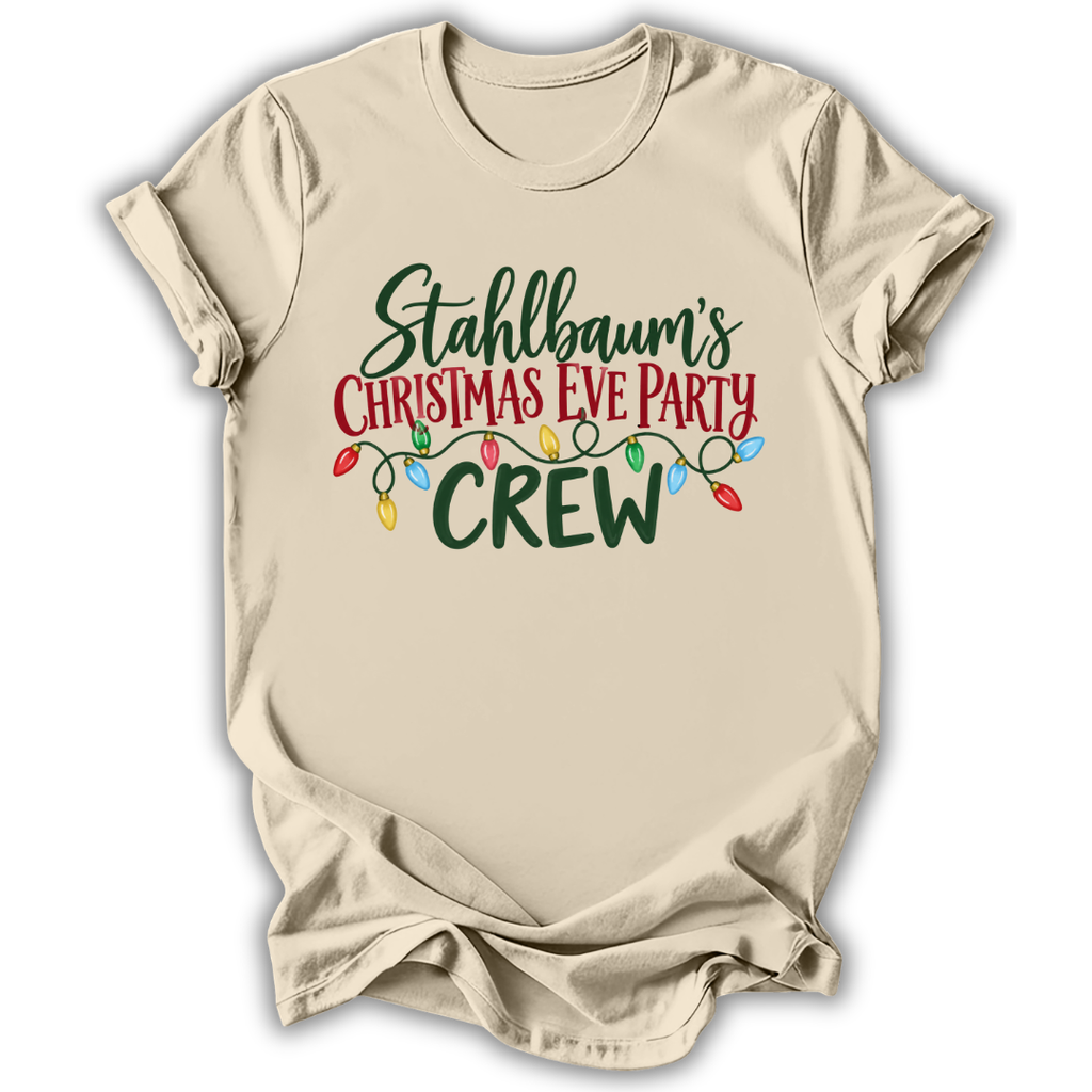 A beige short-sleeve t-shirt with a graphic print that reads 'Stahlbaum's Christmas Eve Party CREW' in green and red lettering, decorated with a string of multicolored Christmas lights, shown on a white background.