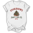 A white short-sleeve t-shirt with a Christmas-themed graphic print. The design features the text 'STAHLBAUM'S PARTY LIKE IT'S 1892' in red and dark green lettering, surrounding an illustration of a decorated Christmas tree with gifts and nutcrackers.