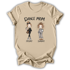 A beige graphic t-shirt featuring cartoon illustrations of two women labeled 'DANCE MOM FRIDAY' and 'SUNDAY'.