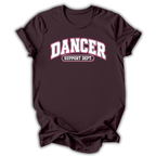 A dark maroon short-sleeve t-shirt with 'DANCER SUPPORT DEPT.' printed in white and pink on the chest, displayed against a clean white background.