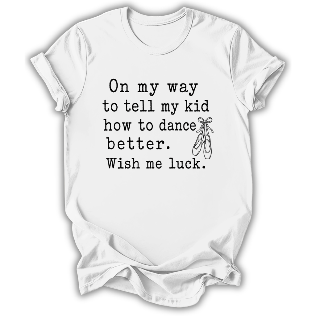 A white short-sleeve crewneck t-shirt with a black printed typewriter-style quote that reads 'On my way to tell my kid how to dance better. Wish me luck.