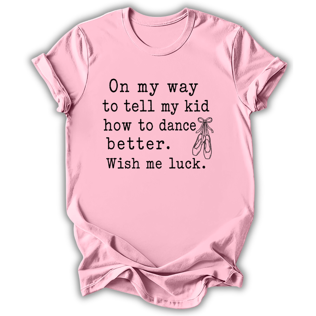 A light pink short-sleeve crewneck t-shirt with black printed text that reads 'On my way to tell my kid how to dance better. Wish me luck.