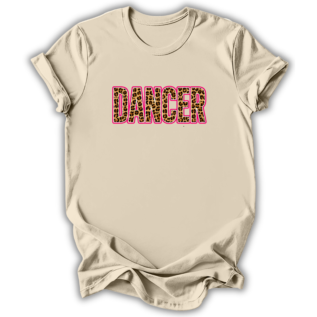 A beige short-sleeve crewneck t-shirt with the word 'DANCER' printed across the chest in bold pink-outlined letters filled with a leopard print pattern of black, brown, and beige, shown on a white background with a soft drop shadow.