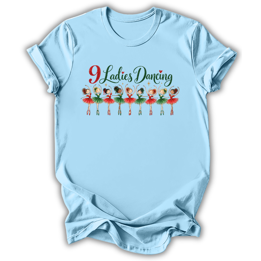 A light blue short-sleeve t-shirt with a graphic on the chest that reads '9 Ladies Dancing' above a row of illustrated ballerinas in red and green tutus, shown on a plain white background.