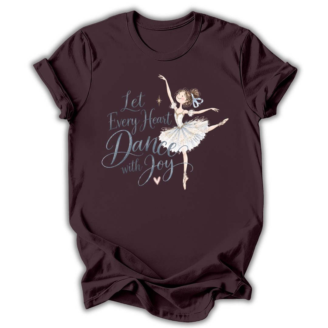 Brown short-sleeve t-shirt with a graphic of a ballerina and the text 'Let Every Heart Dance with Joy' in white and light blue, displayed on a clean white background.
