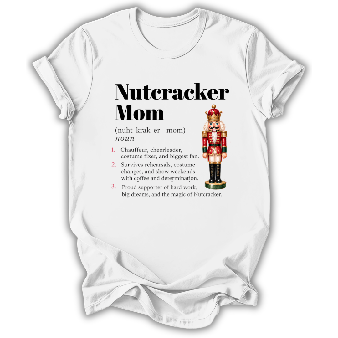 A white short-sleeve crewneck t-shirt with a graphic print on the front. The print features the text 'Nutcracker Mom' in bold black font, followed by a phonetic definition and a list of three characteristics.