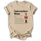 A beige graphic t-shirt laid flat on a white background, featuring a 'Nutcracker Mom' dictionary definition print with a nutcracker illustration.