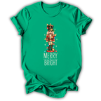 A kelly green kids' short-sleeve t-shirt printed with the “Merry & Bright Nutcracker” graphic design.