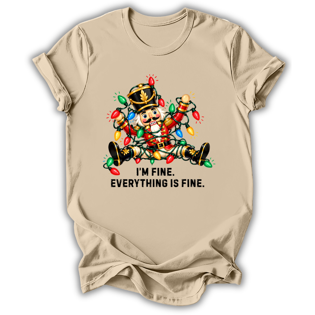 A sand beige short-sleeve t-shirt printed with the “I’m Fine Nutcracker” graphic design.