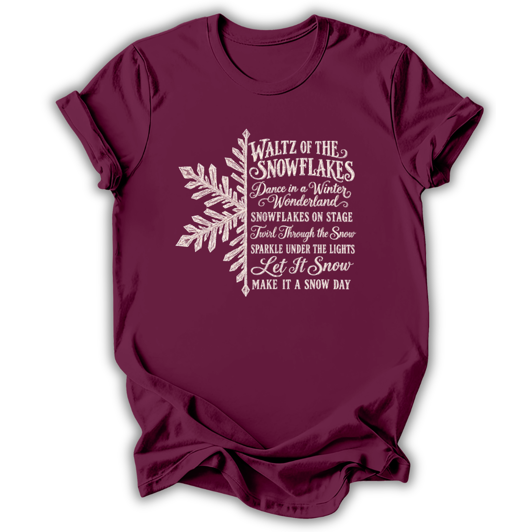 A maroon short-sleeve t-shirt printed with the “Nutcracker Snowflakes” graphic design.