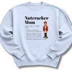 A light blue crewneck sweatshirt featuring a dictionary-style definition of 'Nutcracker Mom'.