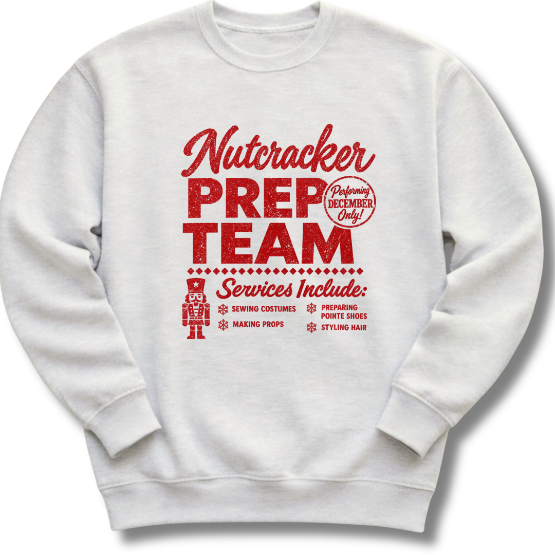 A light ash gray crewneck sweatshirt featuring a vintage-inspired red 'Nutcracker Prep Team' design.