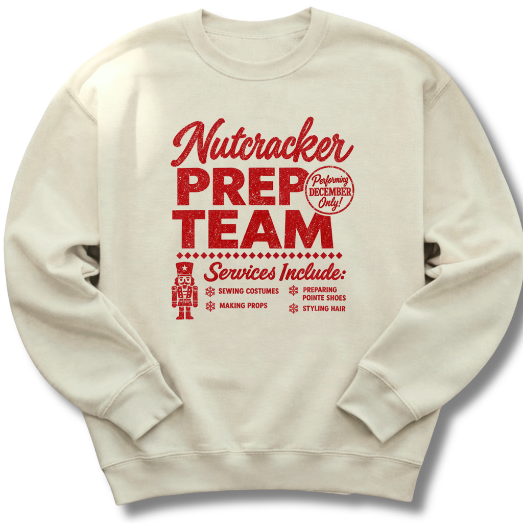 A sand-colored crewneck sweatshirt featuring a vintage-inspired red 'Nutcracker Prep Team' design.