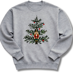 A heather gray youth crewneck sweatshirt featuring a nutcracker nestled among evergreen branches and bright red winter berries.