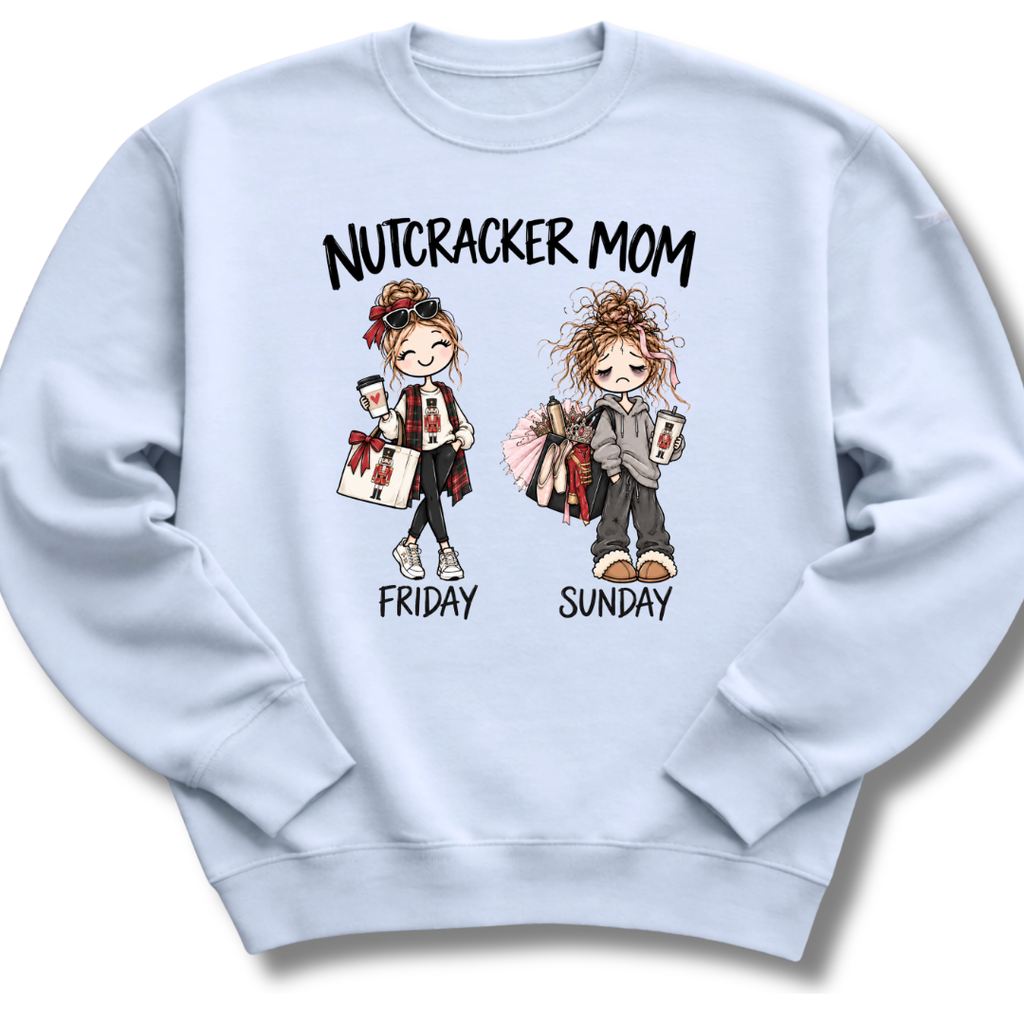 A light blue crewneck sweatshirt featuring an illustrated 'Nutcracker Mom' design with two characters, one ready for Friday's performance and one twirling into Sunday.