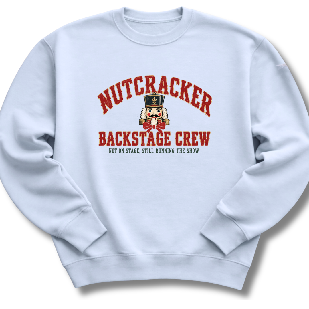 A light blue crewneck sweatshirt featuring a vintage-inspired nutcracker with 'Backstage Crew' lettering.