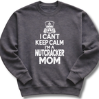 A dark heather gray crewneck sweatshirt featuring a bold white design with a crowned nutcracker and the message 'I Can't Keep Calm, I'm a Nutcracker Mom'.