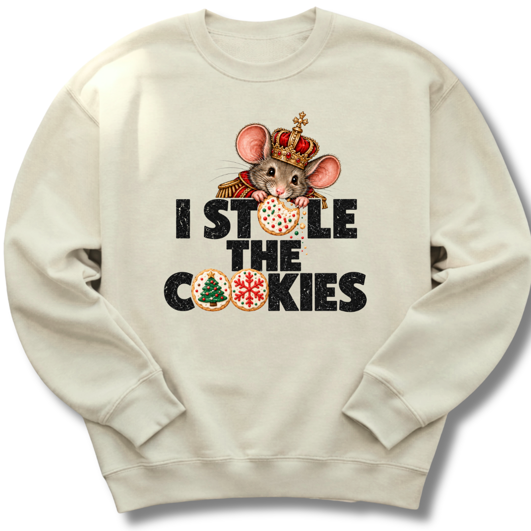 A sand-colored crewneck sweatshirt featuring a crowned character with candy-cane details and festive 'I Stole the Cookies' lettering.
