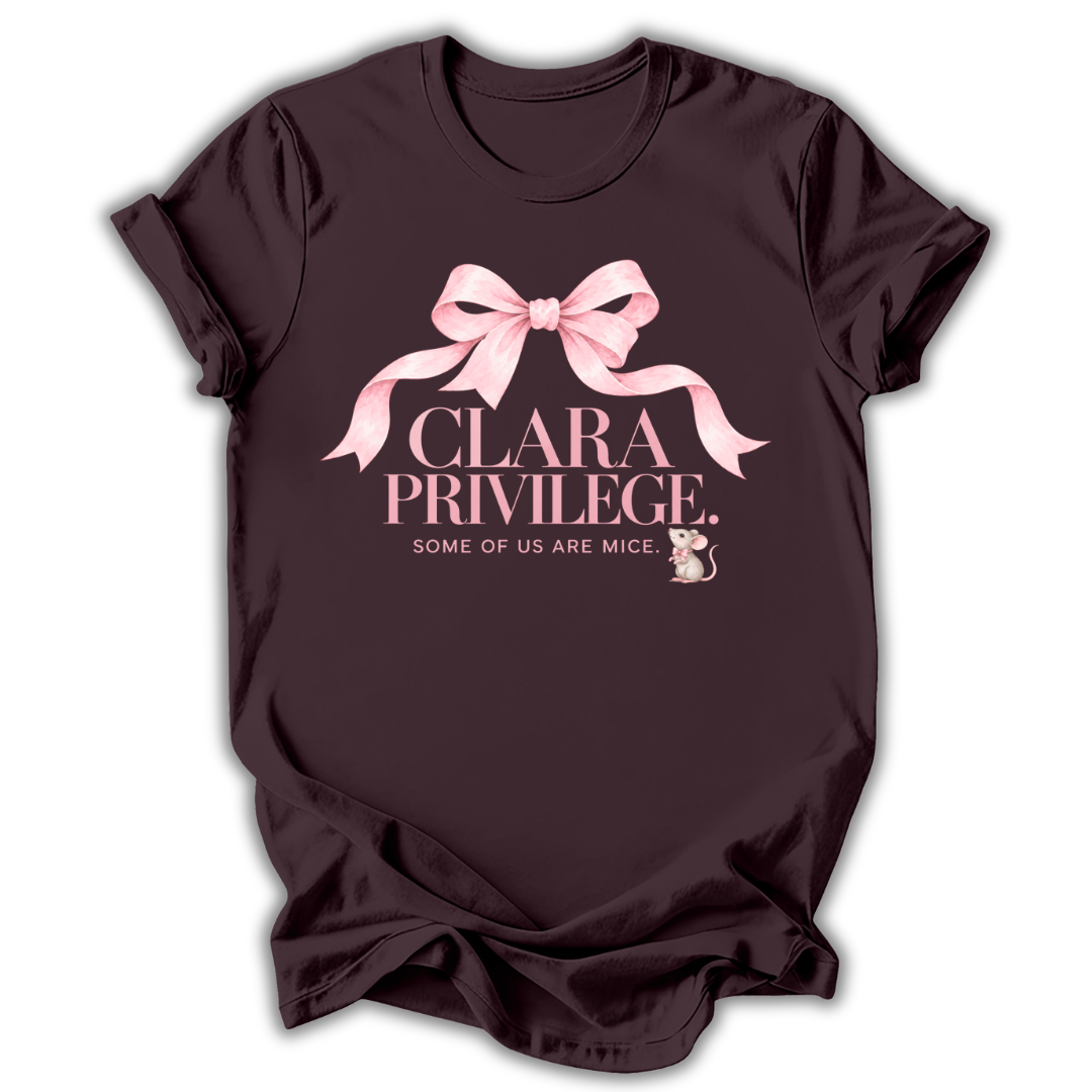 A dark chocolate brown short-sleeve t-shirt printed with the “Clara Privilege” graphic design.