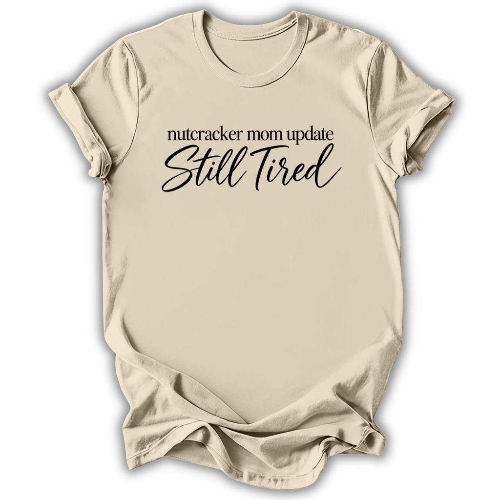 A natural cream short-sleeve t-shirt printed with the “Still Tired Nutcracker Mom” graphic design.