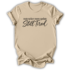 A sand beige short-sleeve t-shirt printed with the “Still Tired Nutcracker Mom” graphic design.