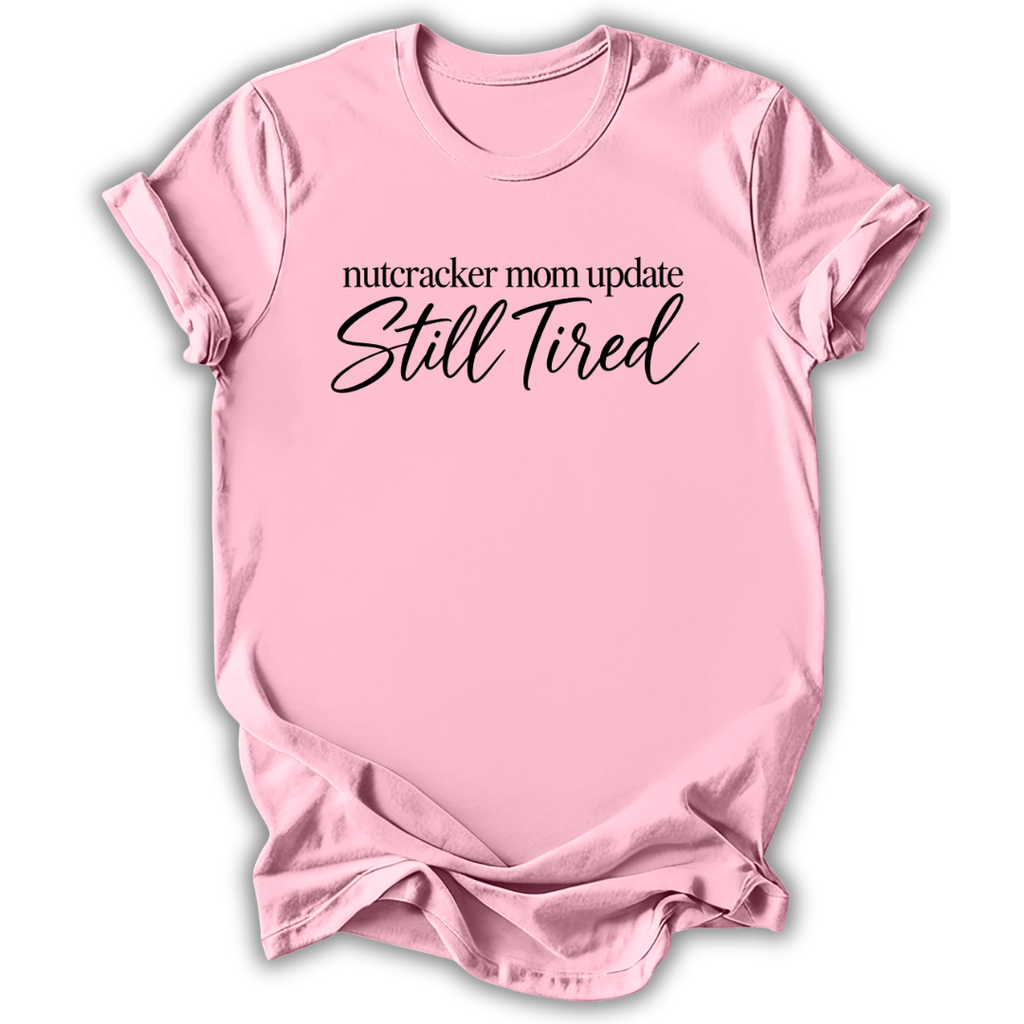 A light pink short-sleeve t-shirt printed with the “Still Tired Nutcracker Mom” graphic design.