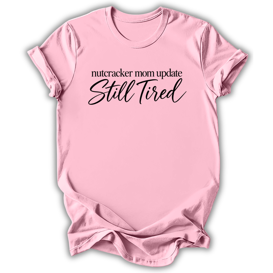 A light pink short-sleeve t-shirt printed with the “Still Tired Nutcracker Mom” graphic design.