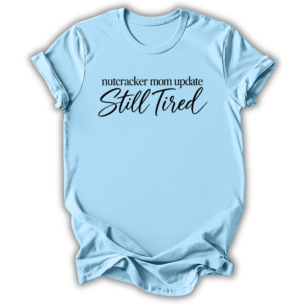 A light blue short-sleeve t-shirt printed with the “Still Tired Nutcracker Mom” graphic design.