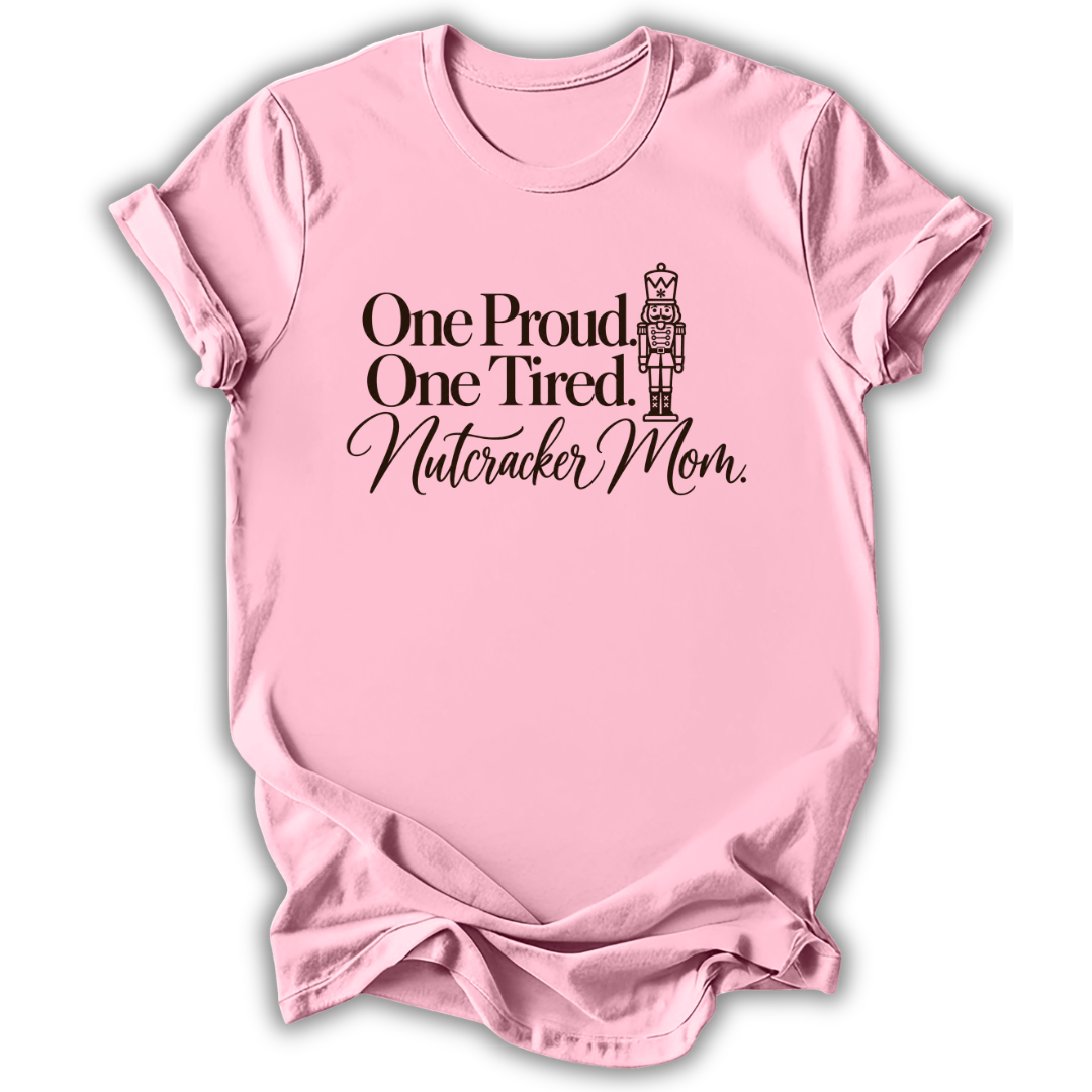 A light pink short-sleeve t-shirt printed with the “Proud & Tired Nutcracker Mom” graphic design.