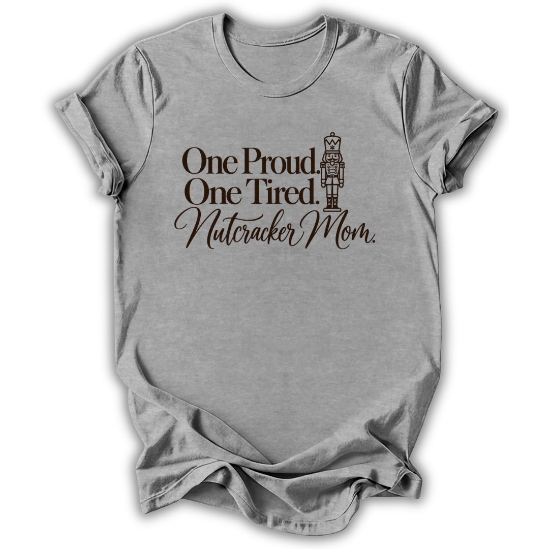 A heather gray short-sleeve t-shirt printed with the “Proud & Tired Nutcracker Mom” graphic design.