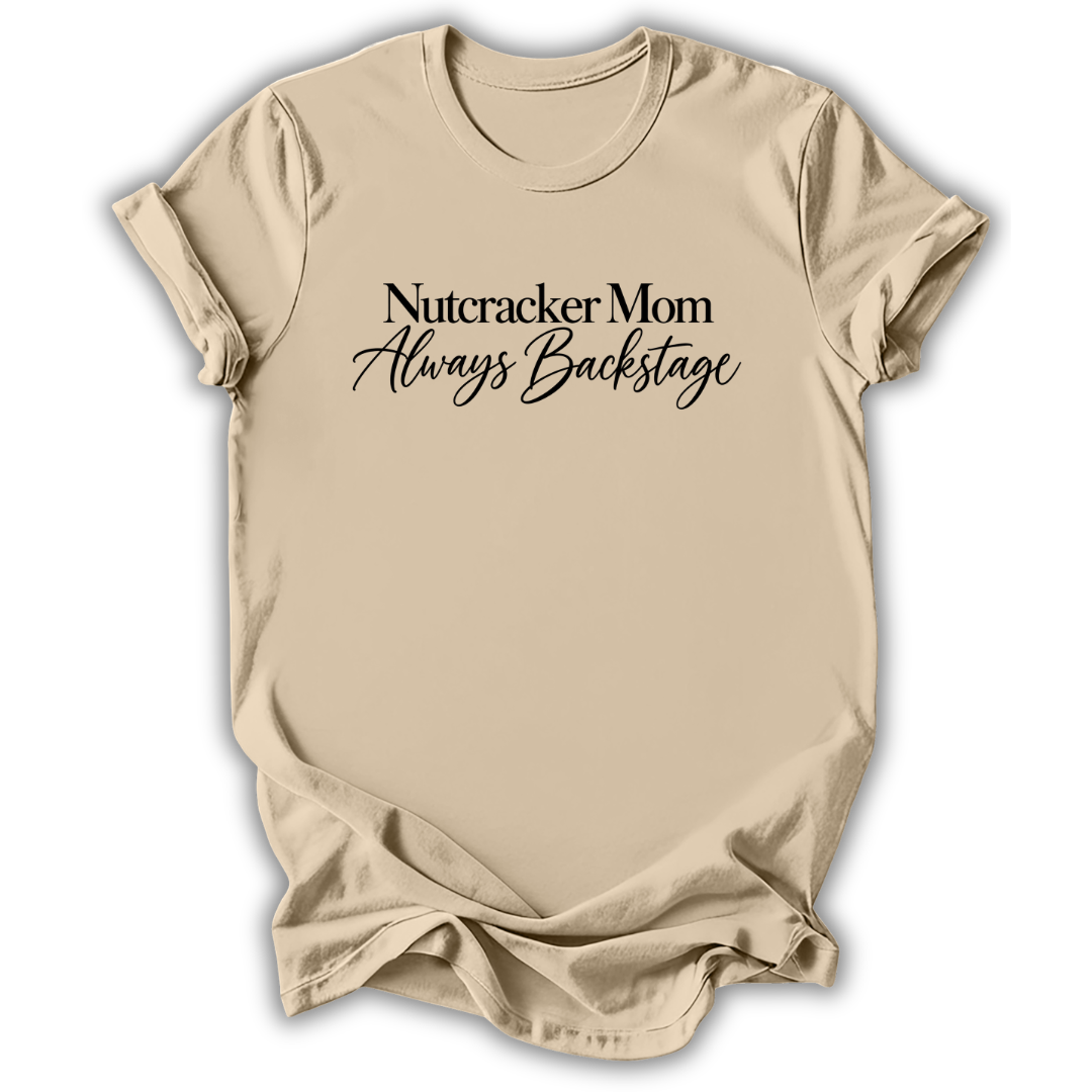 A sand beige short-sleeve t-shirt printed with the “Nutcracker Mom Backstage” graphic design.