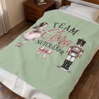 A personalized bedding set featuring a light sage green duvet cover with a 'Team Sara Nutcracker' graphic, styled on a bed in a bedroom setting.