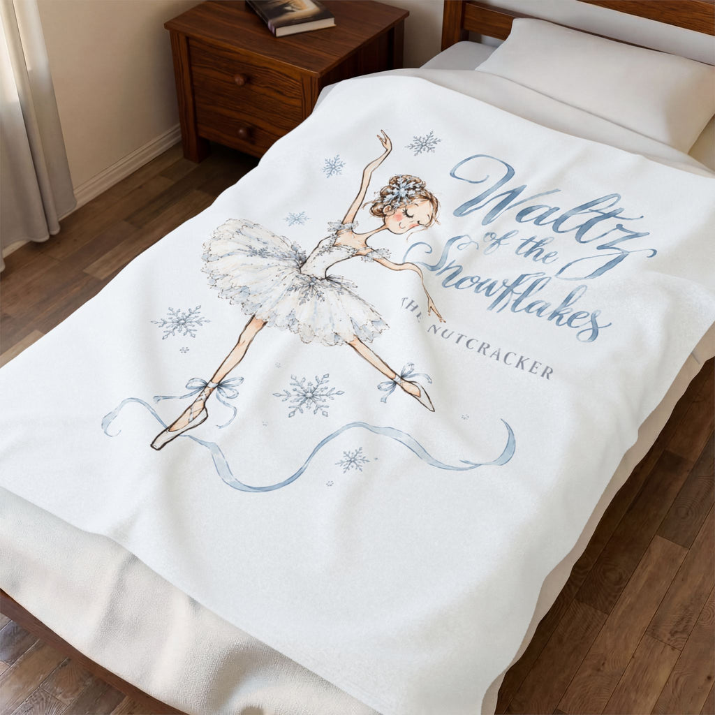 A cream-colored blanket with gold celestial designs and personalized text is draped over a bed in a bedroom setting.