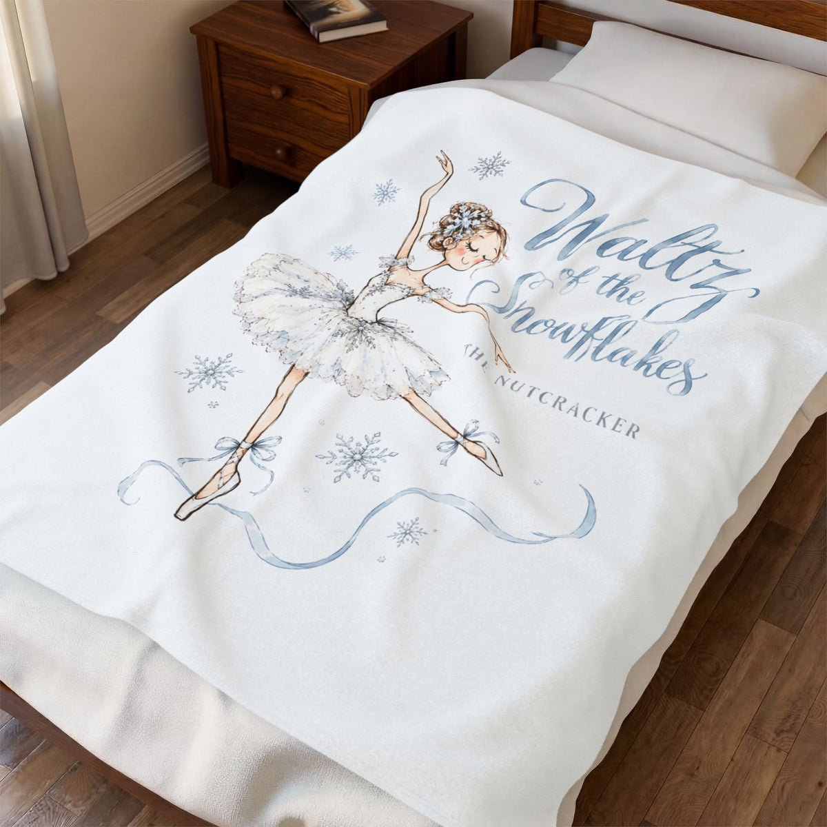 A cream-colored blanket with gold celestial designs and personalized text is draped over a bed in a bedroom setting.