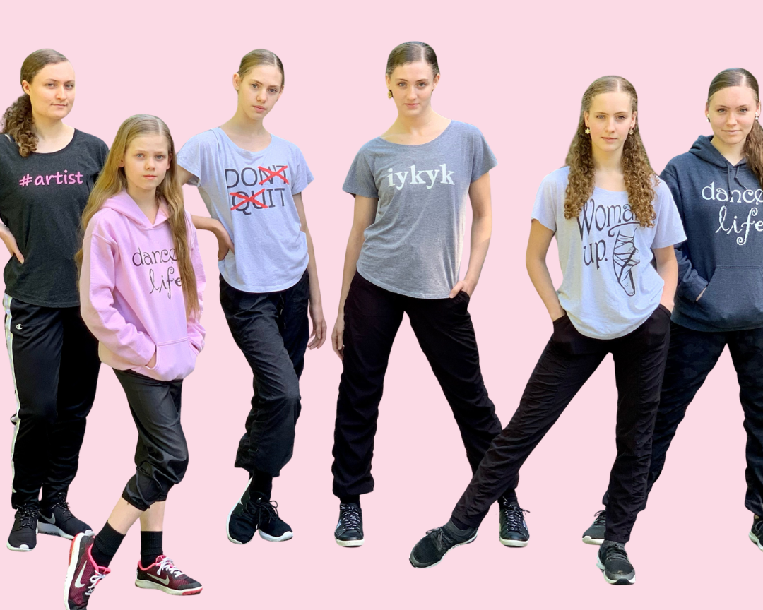 Group of six people wearing casual clothing with various text designs on a pink background